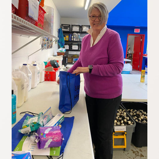 Volunteer packing Seniors' kits with hygiene products.